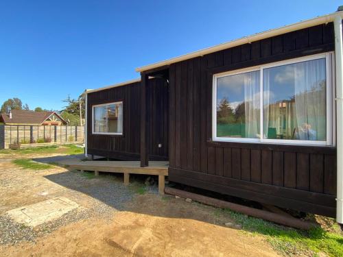 a small wooden house with a bench and windows at Cabaña Clásica - BBQ Cocina Estacionamiento Wifi in Quintay