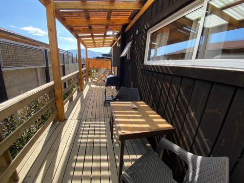 a wooden deck with a table and chairs on a building at Cabaña Clásica - BBQ Cocina Estacionamiento Wifi in Quintay