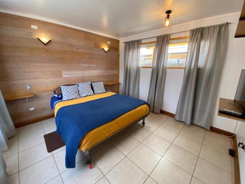 a bedroom with a bed with a wooden wall at Cabaña Clásica - BBQ Cocina Estacionamiento Wifi in Quintay
