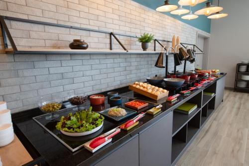 a buffet of food on a counter in a kitchen at Slaviero Ponta Grossa in Ponta Grossa