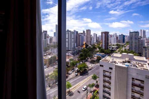 a view of a city from a window in a building at Bugan Recife Boa Viagem Hotel - by Atlantica in Recife