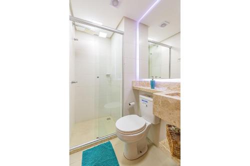 uma casa de banho com um WC e uma cabina de duche em vidro. em Glamour - Stay House Temporada em Gramado