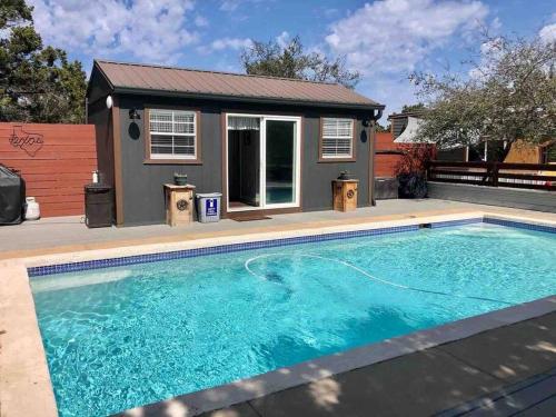a swimming pool in front of a tiny house at The Bobcat Cabin - The Cabins at Rim Rock in Austin