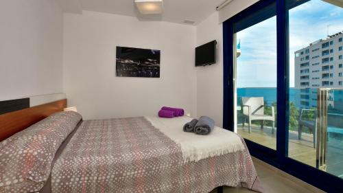 a bedroom with a bed and a view of the ocean at Apartamento Sea Senses in Torrevieja