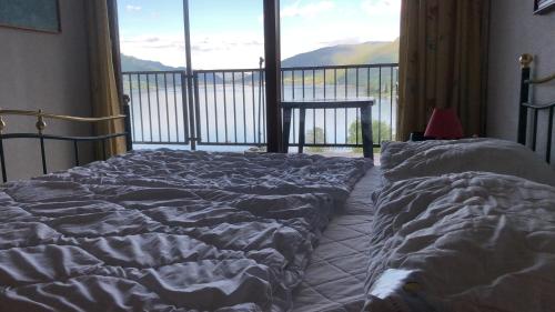 a bedroom with two beds and a large window at Seewohnung Ossiachersee atemberaubendes Panorama in Villach