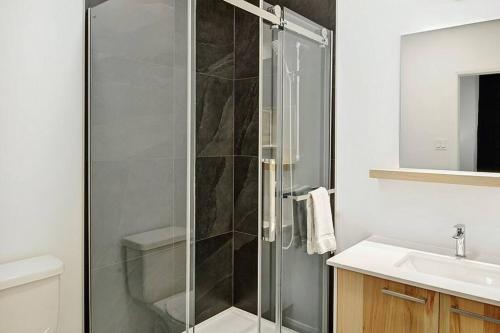 a bathroom with a glass shower and a sink at Blanc 24 - Les Chalets Alpins, Stoneham in Stoneham