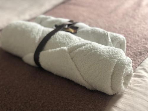 a white towel with a bandaged arm on a bed at Garden House in Kranj