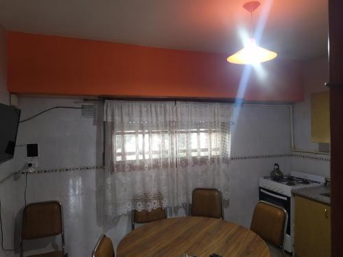 uma cozinha com uma mesa e uma luz no tecto em Casa sur 3 (faro norte) em Mar del Plata