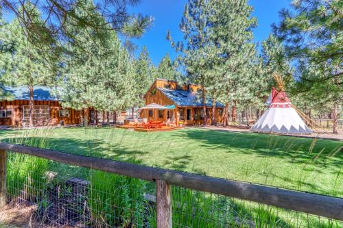 a house with a tent in front of a yard at Sisters Tollgate Retreat with Hot Tub & WiFi in Sisters