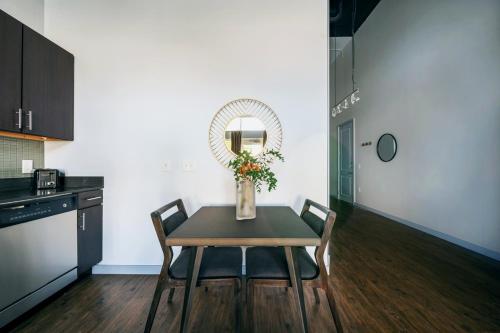 a kitchen with a table with chairs and a vase with flowers at Placemakr Music Row - Vanderbilt in Nashville
