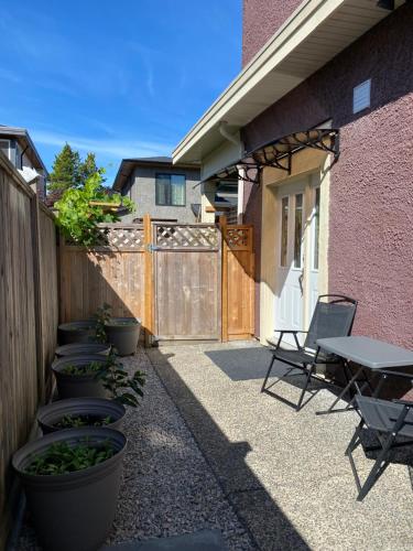 a patio with a table and chairs and a fence at Private cozy suite near Dyke and Fisherman's Wharf in Richmond