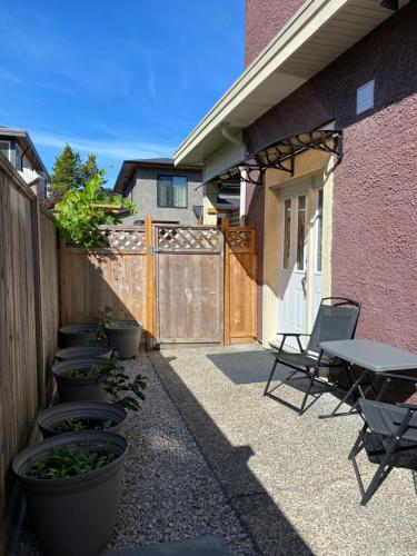 un patio con tavolo, sedie e una recinzione di Private cozy suite near Dyke and Fisherman's Wharf a Richmond