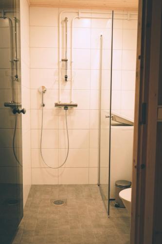 ein Bad mit einer Dusche und einer Glastür in der Unterkunft Heikkilän Pirtti Kelo in Sotkamo