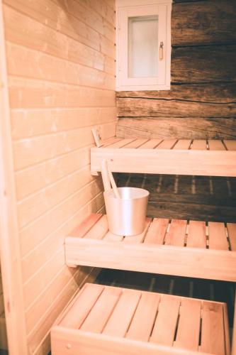 eine Sauna mit zwei Bänken und einem Eimer in der Unterkunft Heikkilän Pirtti Kelo in Sotkamo