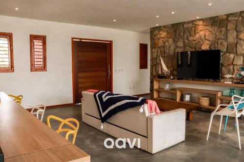 un soggiorno con un divano e una TV di Casa Kairós no Shamballa by Qavi a São Miguel do Gostoso
