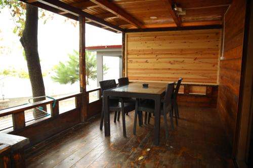 une salle à manger avec une table et des chaises sur une terrasse couverte dans l'établissement Saklı Cennet Bungalow & Tatil Köyü, à Çarşıbaşı