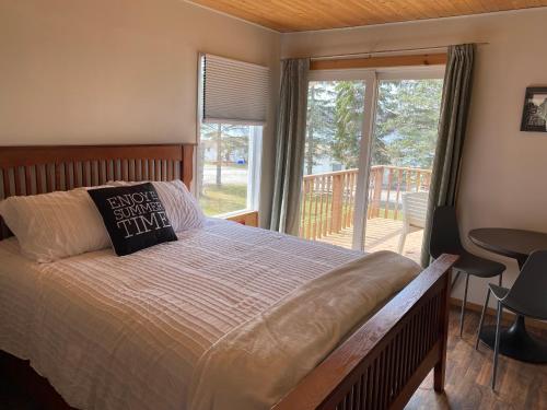 ein Schlafzimmer mit einem Bett und einem großen Fenster in der Unterkunft Merland Park Cottages and Motel in Picton