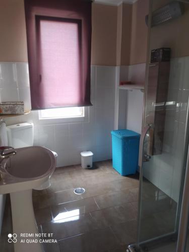 a bathroom with a sink and a glass shower at Vivienda turística Ramón Trillo en Muxía in Muxia