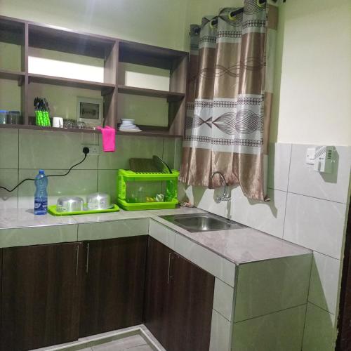 uma cozinha com um lavatório e uma bancada em La Grande cosy studio apartment em Mtwapa