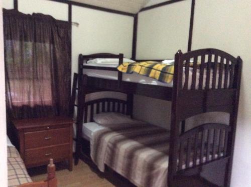 a bedroom with a bunk bed and two chairs at Cabañas casa victoria in Centro Jaramillo