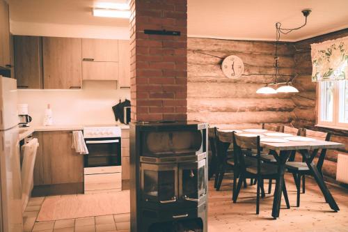 eine Küche mit einem Tisch und einer Uhr an der Wand in der Unterkunft Heikkilän Pirtti Kelo in Sotkamo