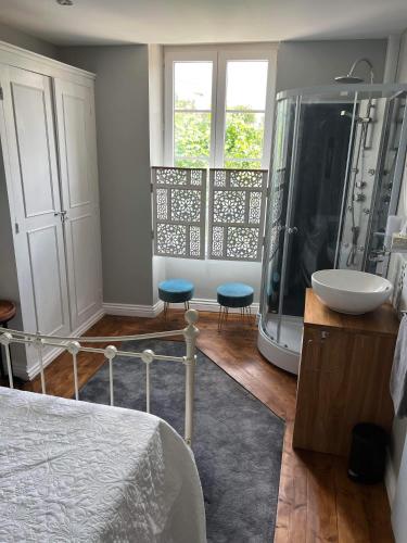 a bedroom with a shower and a bed and a sink at Le Relais D'Aulnay in Aulnay