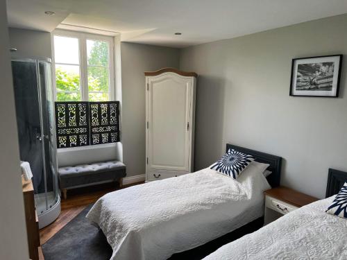 a bedroom with two beds and a window at Le Relais D'Aulnay in Aulnay