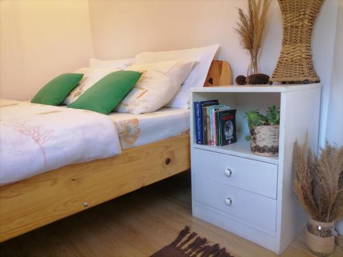 a bedroom with a bed and a night stand with books at Apartmani ZELENI MEDA in Mitrovac