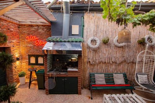 a patio with a grill and a table and a bench at Villa Elezi in Korçë
