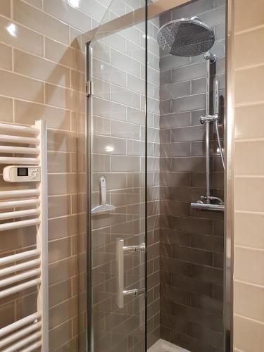 une douche avec une porte vitrée dans une salle de bain dans l'établissement Chambres Supérieures privées, plein centre-ville de Nice - HUBERT, à Nice