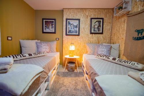 a room with two beds and a table with a lamp at Villa Elezi in Korçë