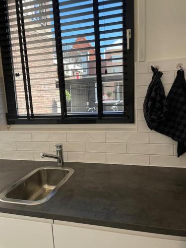 a kitchen counter with a sink and a window at Vakantiehuis in het hart van Medemblik in Medemblik