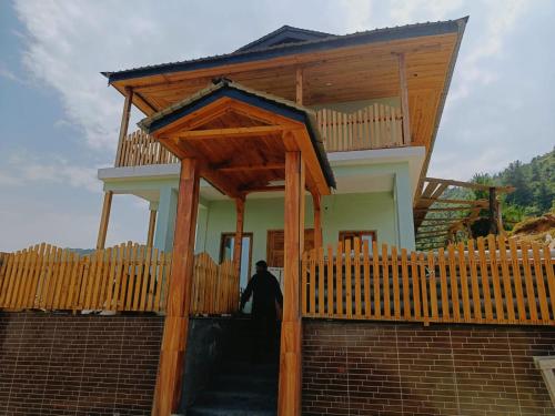 a man standing in front of a wooden building at Veda Inn in Chakrāta