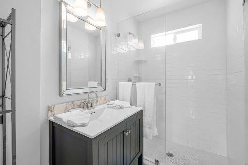 a white bathroom with a sink and a shower at Newport Coastal Comfort in Newport Beach