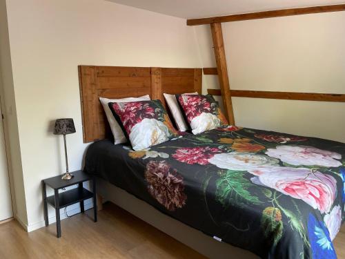 een slaapkamer met een bed met een houten hoofdeinde bij Vakantiehuis in het hart van Medemblik in Medemblik
