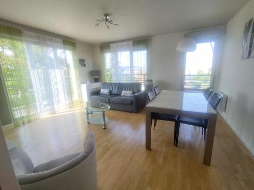 un salon avec un canapé et une table dans l'établissement Bord de Seine, à Carrières-sous-Poissy