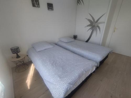 - 2 lits jumeaux dans une chambre avec une table dans l'établissement Bord de Seine, à Carrières-sous-Poissy