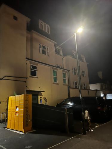 a black car parked next to a street light at Lovely 2 bedroom Flat at Palm Court in Bournemouth,5 minutes away from beach, whole flat is yours for the time you stayed in Bournemouth