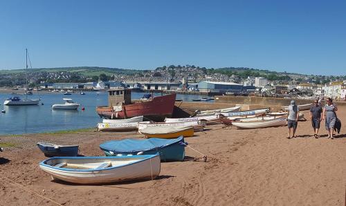 a group of people standing on a beach with boats at Brookbank Luxury 4 Bed House in Teignmouth