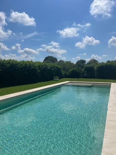 a swimming pool with blue water in a yard at Dimorae Camà in Cisternino