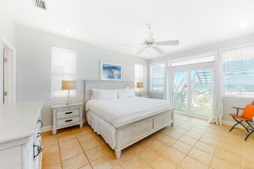 a white bedroom with a bed and a window at A Sea Of Sand & Stars in St. George Island