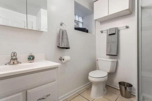 een witte badkamer met een toilet en een wastafel bij The Wrigleyville Garden 200 Steps to Wrigley-2BR in Chicago