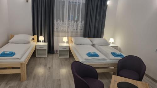 sypialnia z 2 łóżkami i 2 krzesłami w obiekcie Etna 3 Dom z Parkingiem Rzeszów Morgowa w mieście Rzeszów