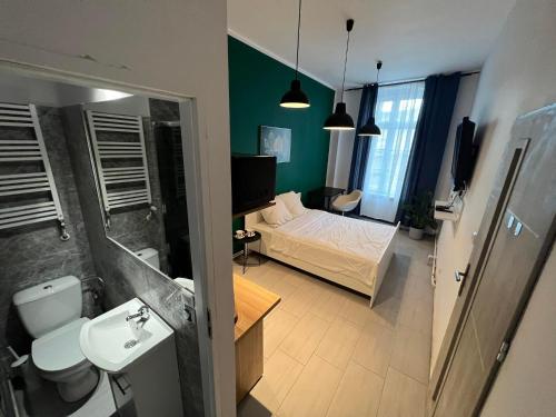 a bathroom with a bedroom with a bed and a sink at Apartamenty Nowy Rynek in Bydgoszcz