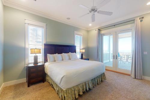 - une chambre avec un grand lit et un balcon dans l'établissement Le Reve, à Île Saint Georges