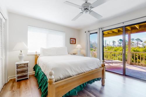 a bedroom with a bed and a balcony at Our Thyme in St. George Island
