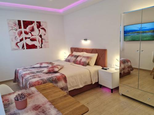 a bedroom with a bed and a table and a mirror at Restaurant & Apartments Getaway Pri Kobalu in Vipava