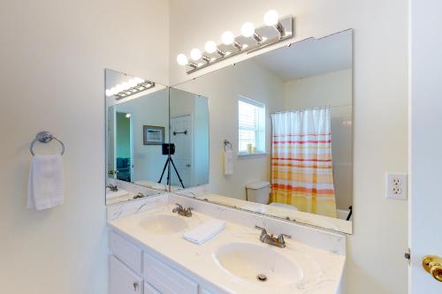 a bathroom with a sink and a large mirror at Footprints In The Sand in St. George Island