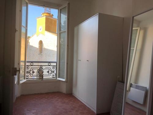 a room with a large window and a clock tower at le calme à Salernes in Salernes