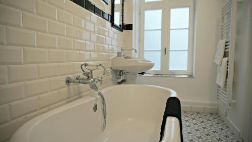 une salle de bain avec une baignoire et un lavabo dans l'établissement Little Suite - Oscar, à Lille